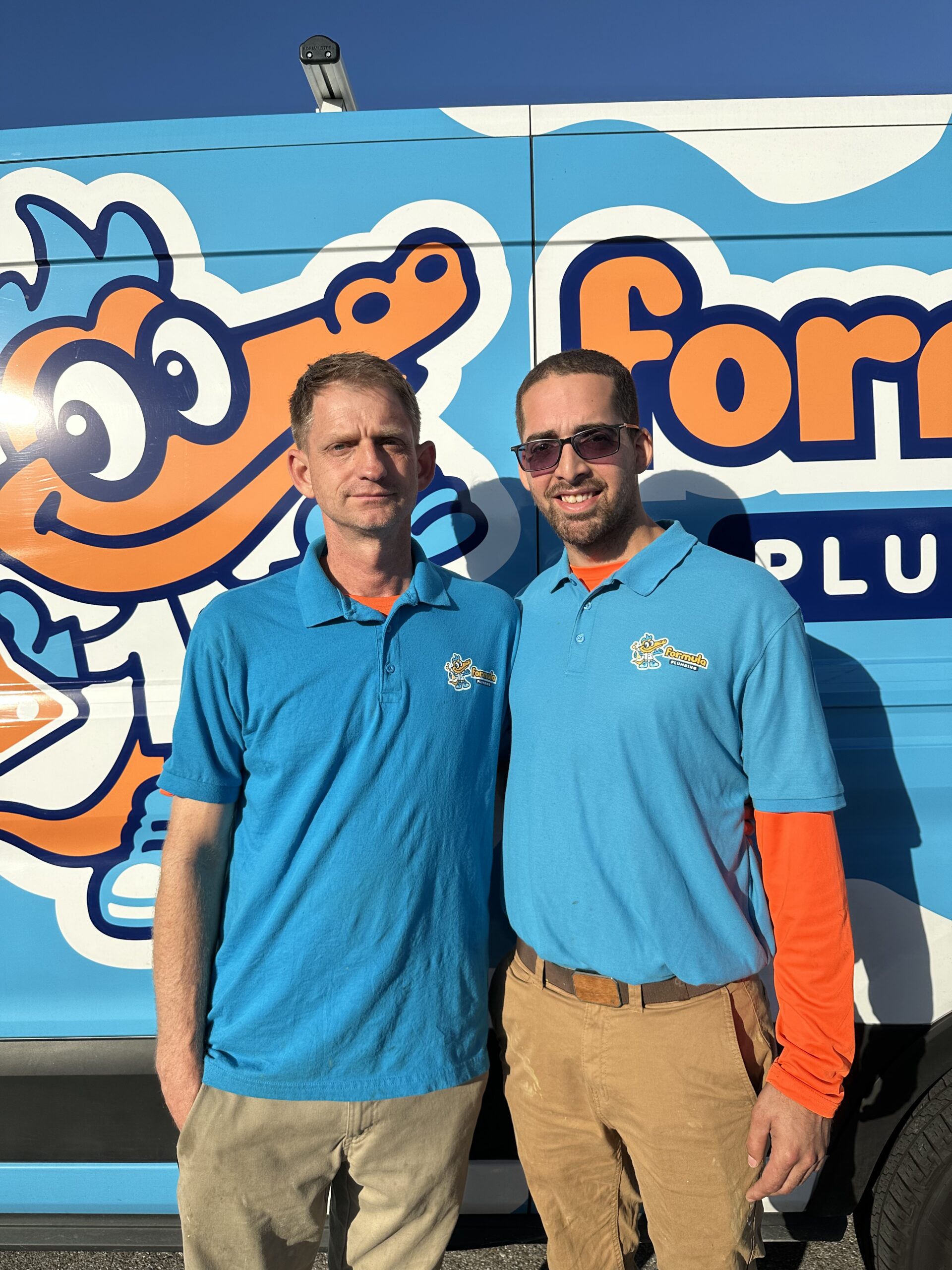 Formula Plumbing technicians in uniform in front of company van, Tampa Bay