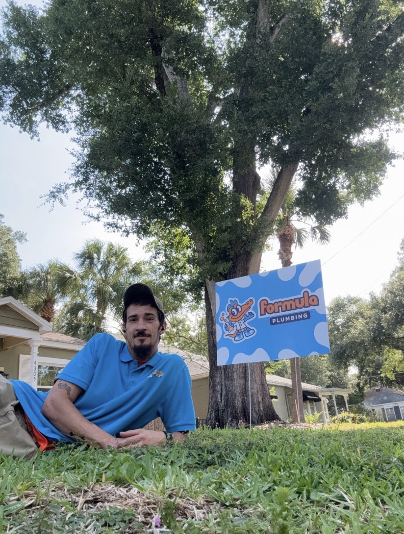 Formula Plumbing employee outdoors with company yard sign in Tampa Bay