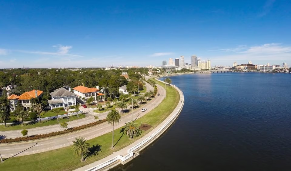 Aerial view of Bayshore Boulevard curving along Hillsborough Bay in South Tampa with the downtown Tampa skyline in the background